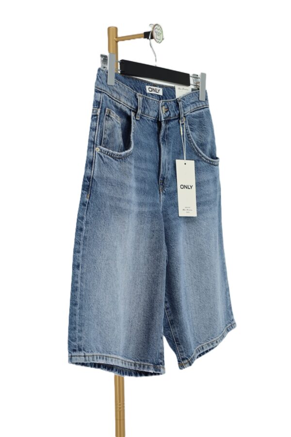 Boczny profil szerokich spodenek jeansowych jorts ONLY z metką producenta.