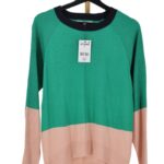 Sweter damski zielony color block z raglanowymi rękawami na wieszaku z przodu.