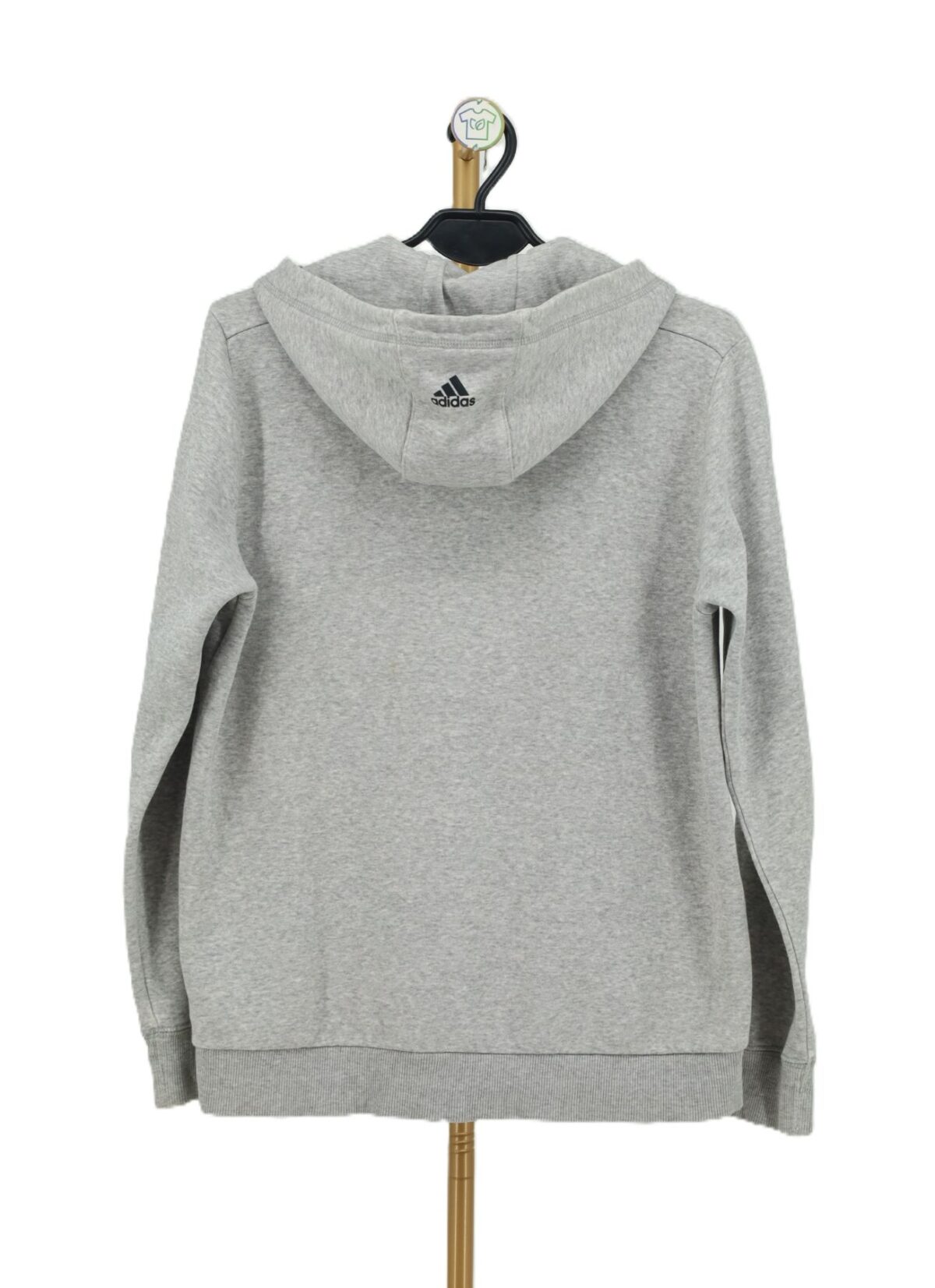Tył szarej bluzy z kapturem Adidas z małym czarnym logo na kapturze.