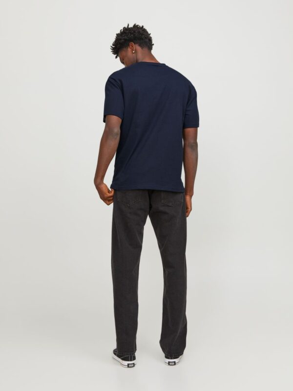 Tył męskiej granatowej koszulki bawełnianej Jack & Jones na modelu z czarnymi jeansami.