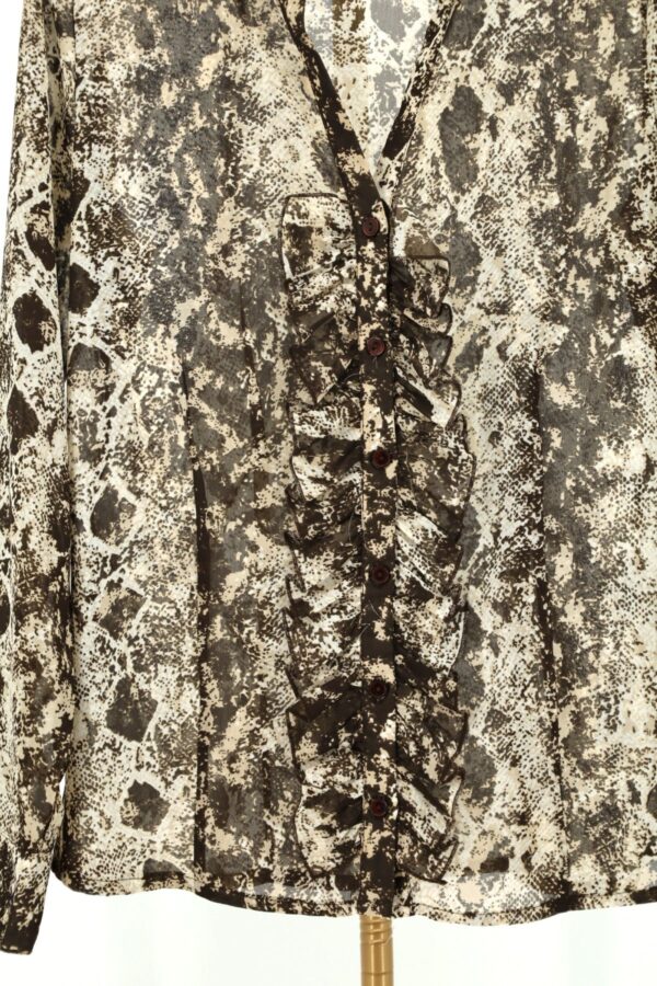Detal guzików i marszczonych falban przy dekolcie koszuli python print.Detal guzików i marszczonych falban przy dekolcie koszuli python print.